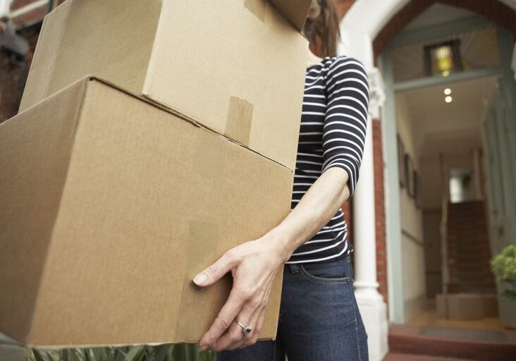 woman-carrying-brown-boxes-from-house-royalty-free-image-108353192-1553390570